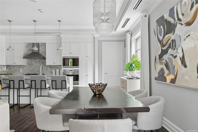 dining space featuring dark hardwood / wood-style flooring, ornamental molding, and an inviting chandelier