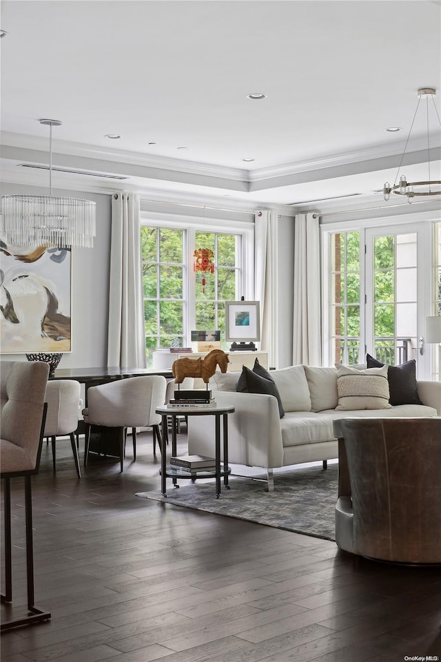 living room with dark hardwood / wood-style flooring, a wealth of natural light, and a chandelier