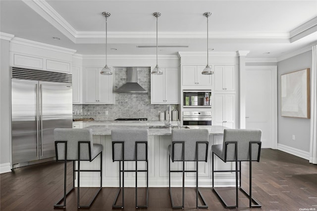 kitchen featuring light stone countertops, wall chimney range hood, a kitchen island with sink, white cabinets, and black appliances