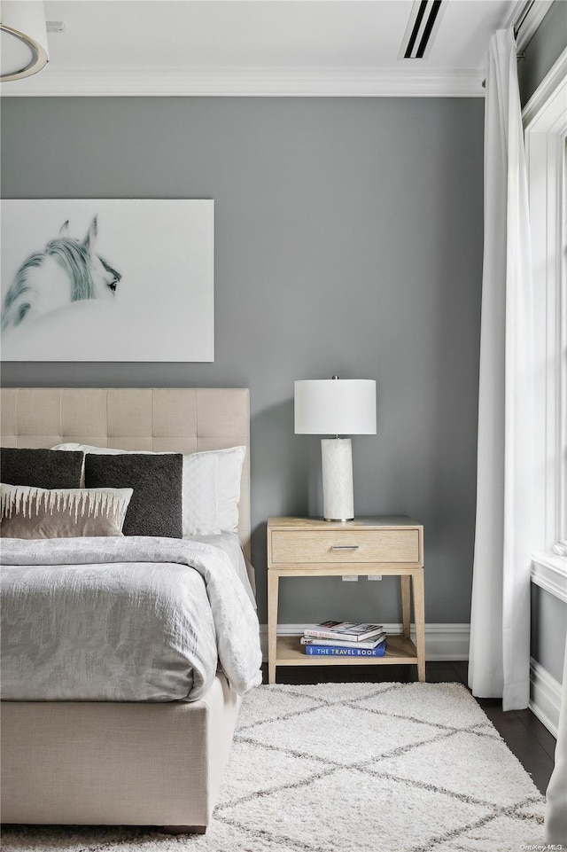 bedroom featuring wood-type flooring and ornamental molding