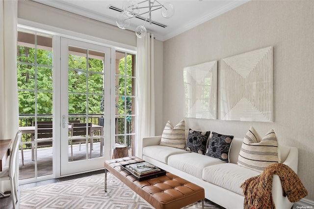 living room with a notable chandelier, wood-type flooring, and crown molding