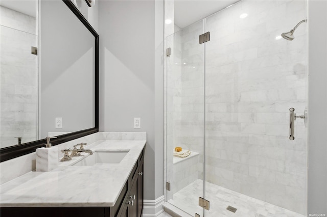 bathroom featuring vanity and a shower with door