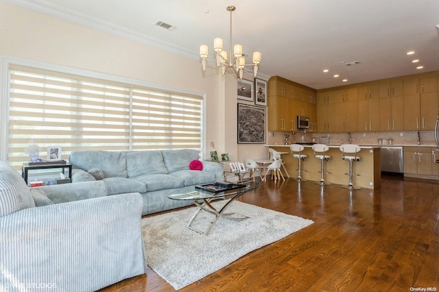 living room with a chandelier, dark hardwood / wood-style floors, and ornamental molding