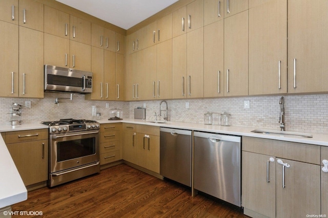 kitchen with backsplash, stainless steel appliances, dark wood-type flooring, and sink