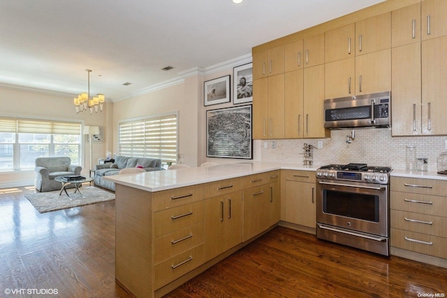 kitchen with kitchen peninsula, appliances with stainless steel finishes, ornamental molding, dark wood-type flooring, and decorative light fixtures