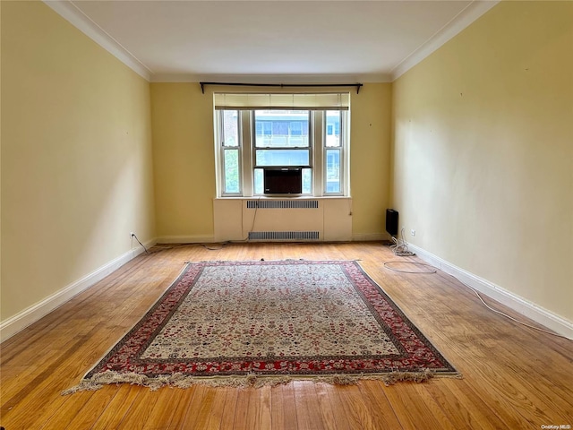 unfurnished room with hardwood / wood-style floors, cooling unit, ornamental molding, and radiator