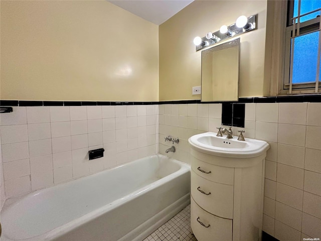 bathroom with vanity, a tub to relax in, and tile walls