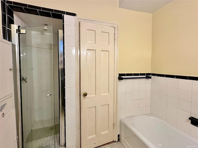 bathroom featuring tile patterned floors, shower with separate bathtub, and tile walls