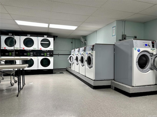 clothes washing area with stacked washing maching and dryer and washing machine and clothes dryer