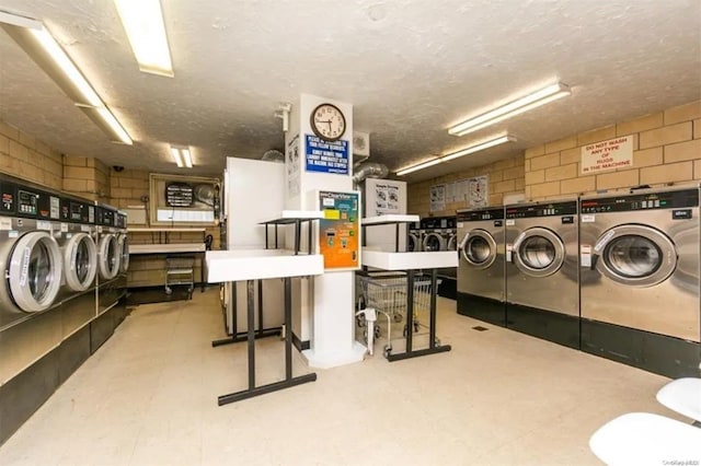 washroom featuring washing machine and dryer and a textured ceiling