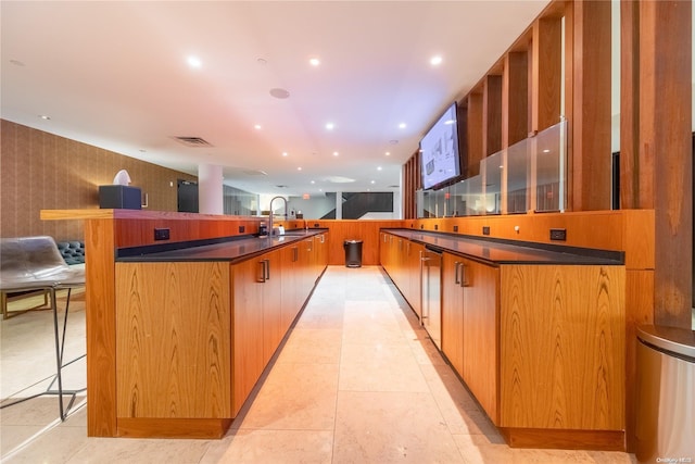 kitchen featuring light tile patterned flooring, a kitchen breakfast bar, a large island, and sink