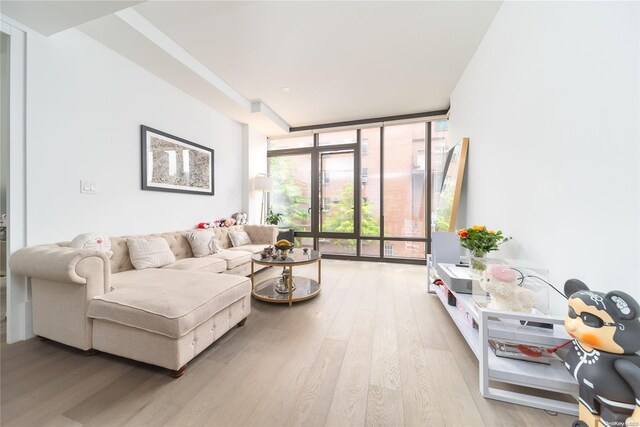 living room featuring light wood-type flooring and expansive windows