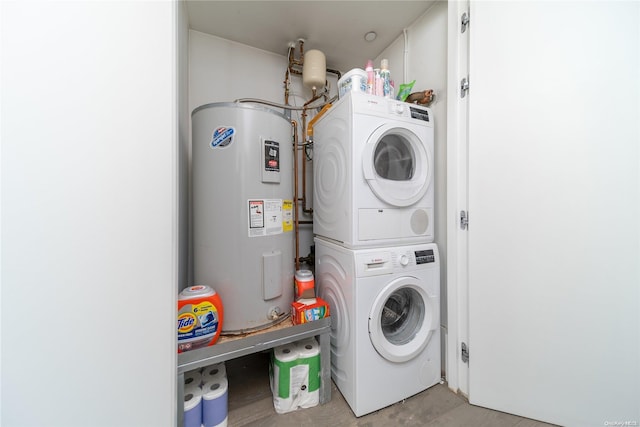 laundry room with water heater and stacked washer and clothes dryer