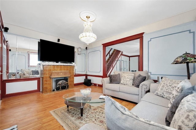 living room featuring a fireplace, hardwood / wood-style floors, and a notable chandelier