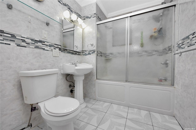 bathroom with ornamental molding, bath / shower combo with glass door, tile walls, tile patterned flooring, and toilet