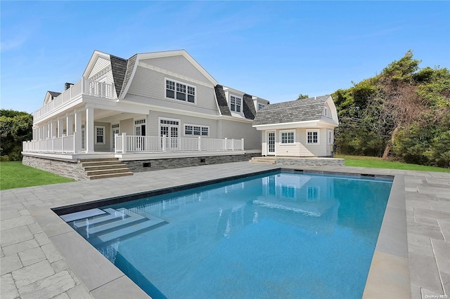 back of property with an outbuilding and a patio