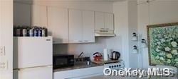 kitchen featuring white cabinets and white fridge