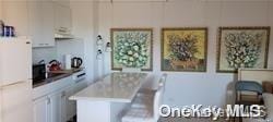 kitchen featuring a kitchen bar and white cabinetry