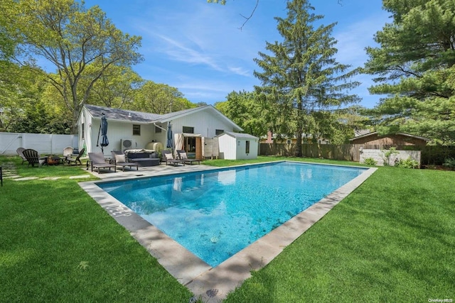 view of swimming pool featuring an outdoor living space, a storage unit, and a lawn