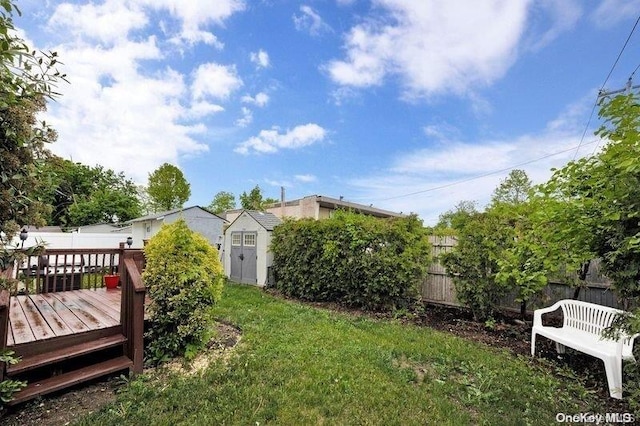 view of yard with a wooden deck and a shed