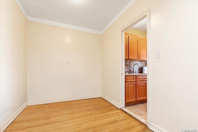 interior space featuring sink, light hardwood / wood-style flooring, and ornamental molding