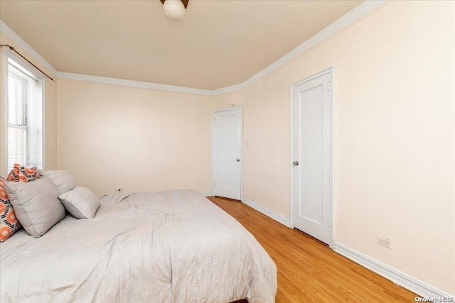 bedroom featuring hardwood / wood-style floors and crown molding