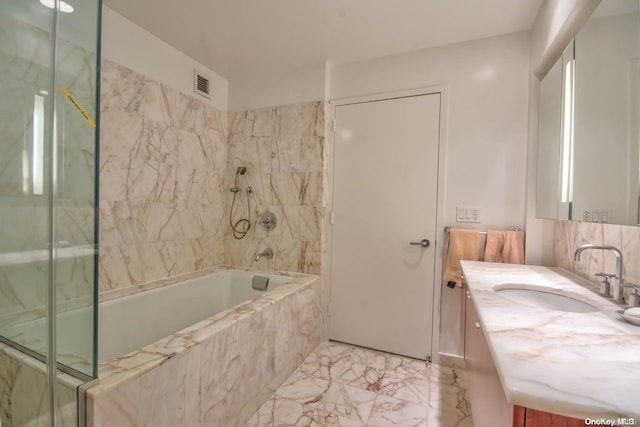 bathroom featuring vanity and tiled shower / bath combo