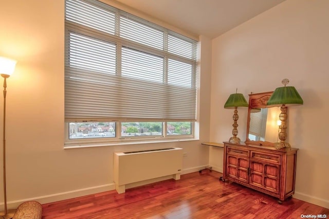 interior space with hardwood / wood-style floors and radiator heating unit