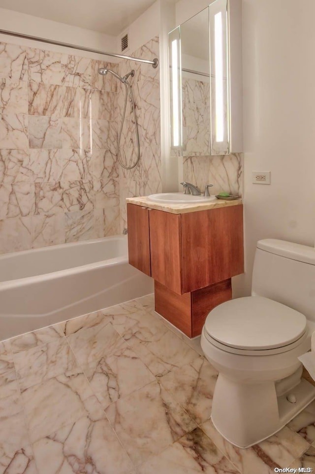 full bathroom featuring vanity, toilet, and tiled shower / bath