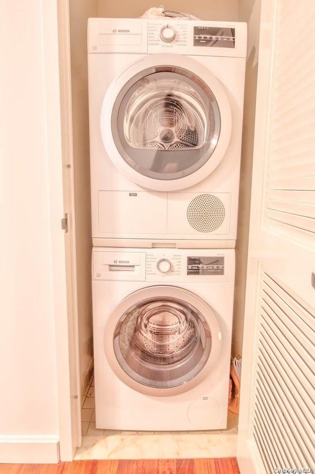 laundry area with tile patterned flooring and stacked washer / drying machine