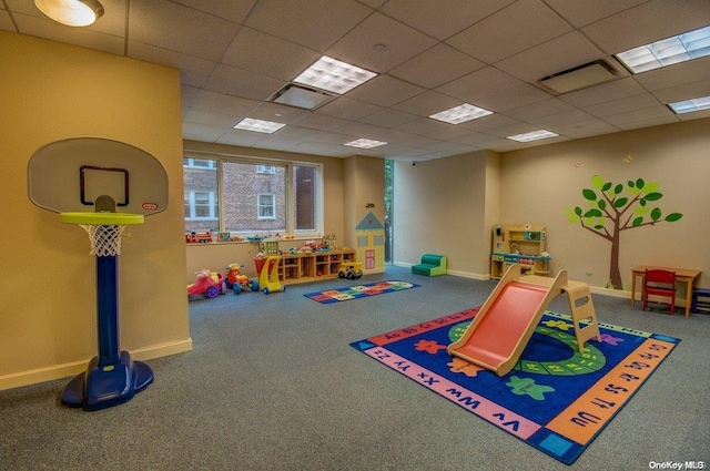 game room with a paneled ceiling and carpet