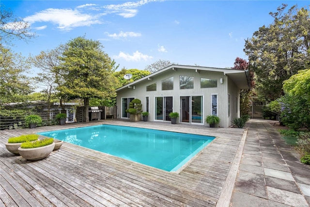 view of pool with a wooden deck and a grill