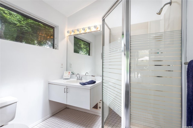 bathroom featuring tile patterned floors, vanity, toilet, and walk in shower