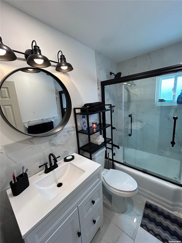 full bathroom with decorative backsplash, toilet, vanity, and combined bath / shower with glass door