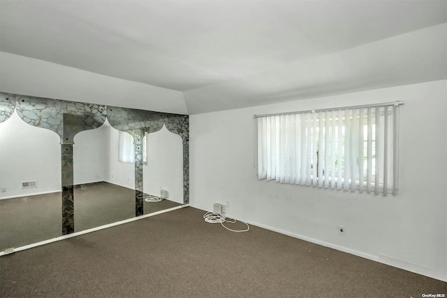 empty room with carpet flooring, plenty of natural light, and vaulted ceiling