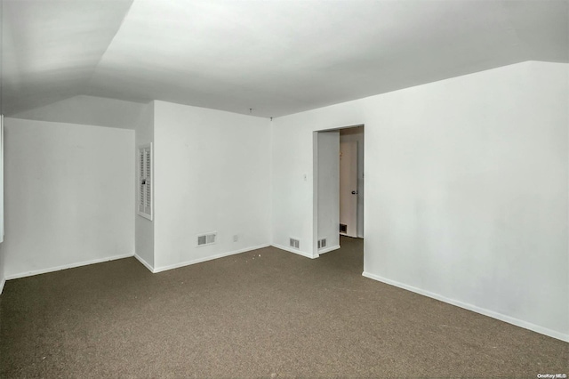 interior space with lofted ceiling and dark colored carpet