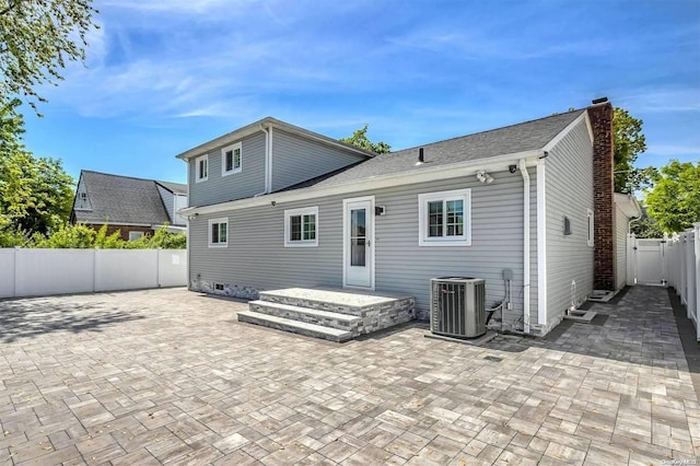 rear view of property featuring central air condition unit and a patio