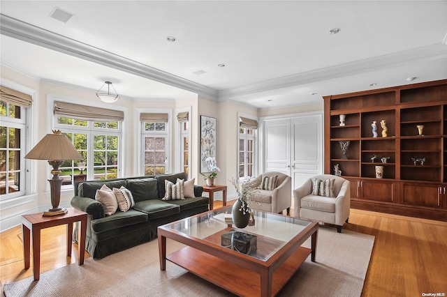 living room with light hardwood / wood-style floors and crown molding