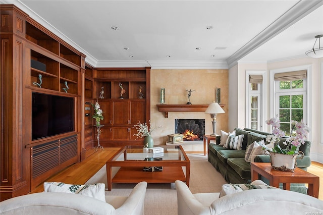 living room featuring a high end fireplace, ornamental molding, and light wood-type flooring