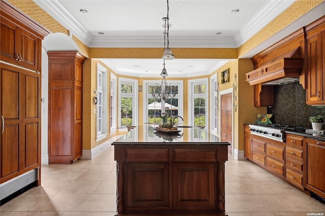 kitchen featuring custom exhaust hood, crown molding, decorative light fixtures, a kitchen island, and stainless steel gas cooktop