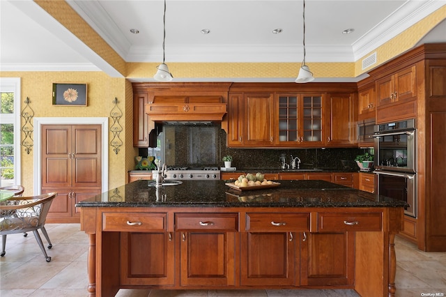 kitchen featuring hanging light fixtures, stainless steel appliances, and a kitchen island with sink