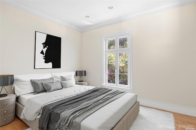 bedroom featuring light wood-type flooring and crown molding