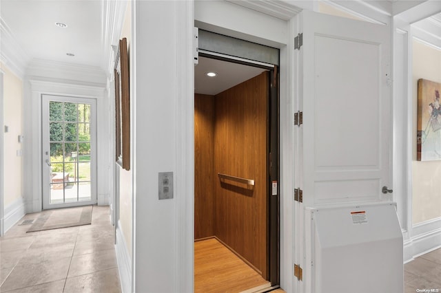 corridor featuring light tile patterned floors, ornamental molding, and elevator