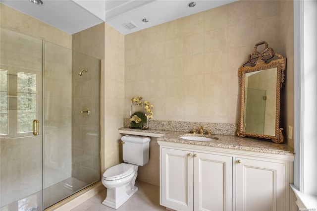 bathroom featuring walk in shower, tile patterned flooring, toilet, vanity, and tile walls