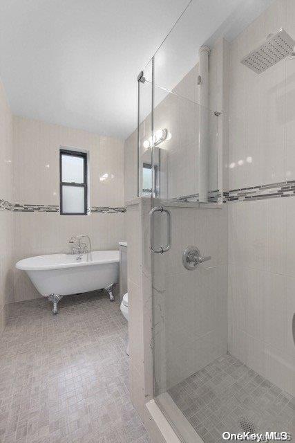 bathroom with independent shower and bath and tile walls