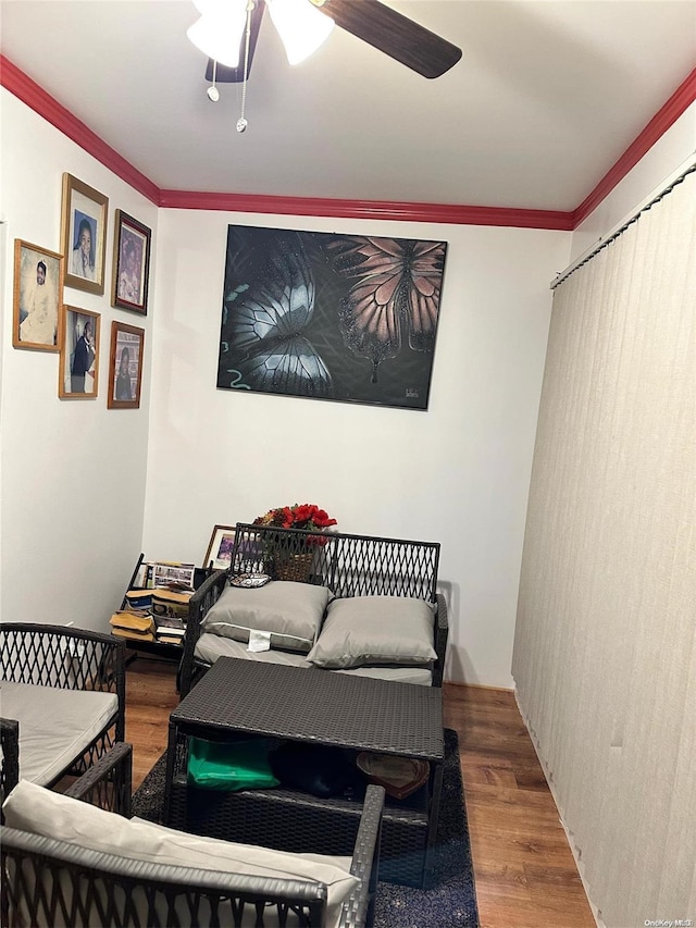 interior space featuring wood-type flooring, ceiling fan, and ornamental molding