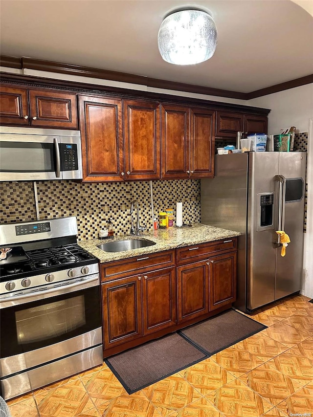 kitchen with sink, stainless steel appliances, light stone counters, decorative backsplash, and ornamental molding