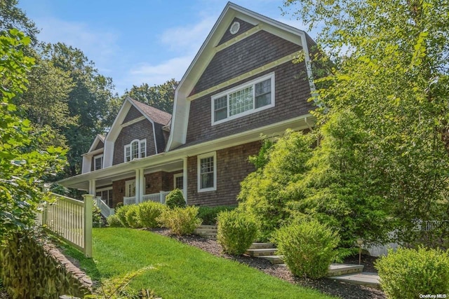 exterior space with a yard, a gambrel roof, and a porch