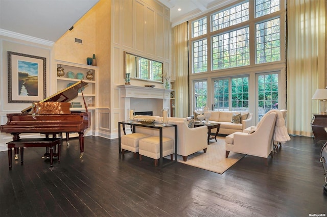 living room with hardwood / wood-style floors, ornamental molding, and a high ceiling