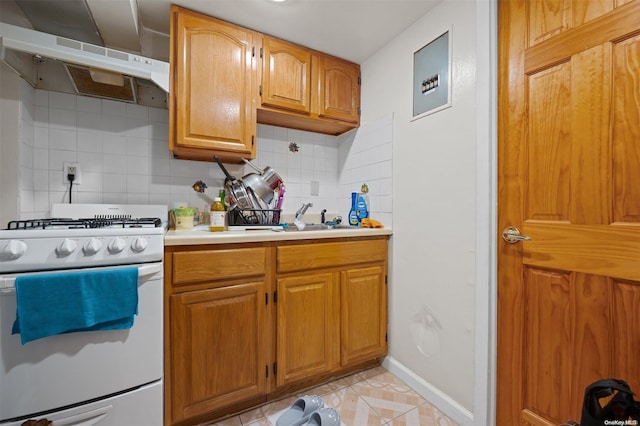 kitchen with exhaust hood, sink, tasteful backsplash, light tile patterned flooring, and white range oven